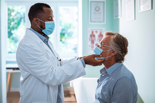 Doctor examining an adult male patient.