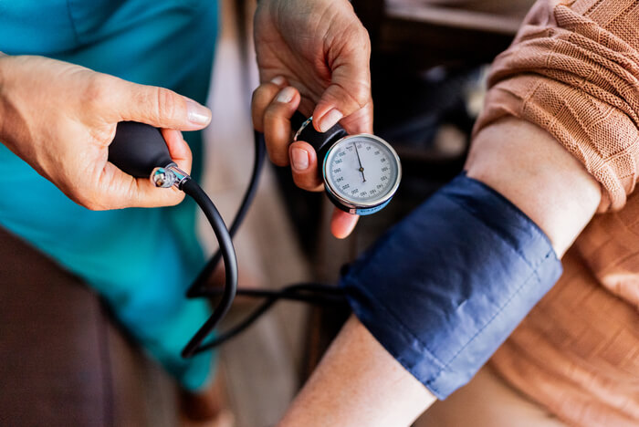 Medical professional taking a blood pressure reading with a cuff.