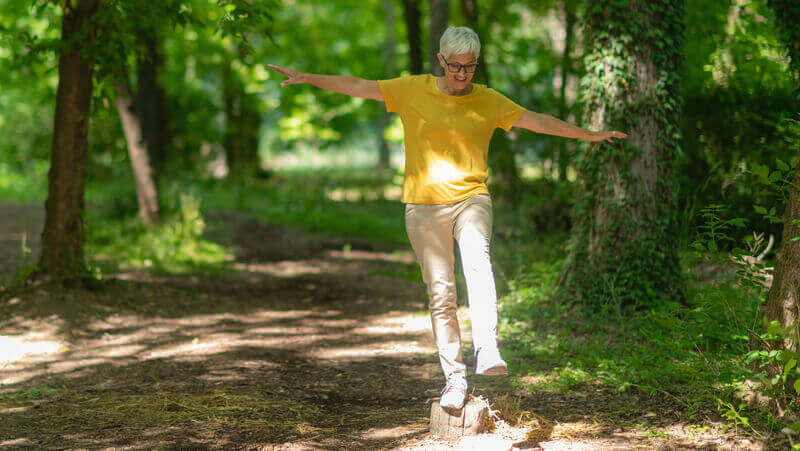Older woman exercising on a nature trail.