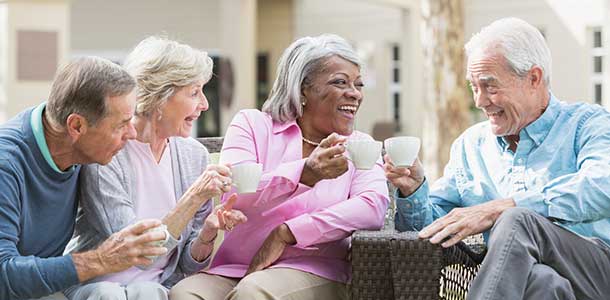 Altos amigos al aire libre bebiendo café.