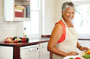 Mujer cortando verduras en una cocina