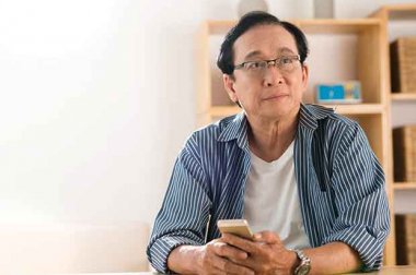 Man sitting at a table with his phone in his hands