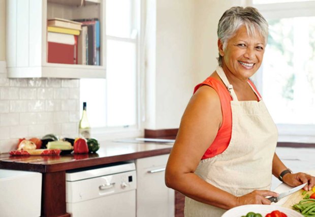 Mujer cortando verduras en una cocina