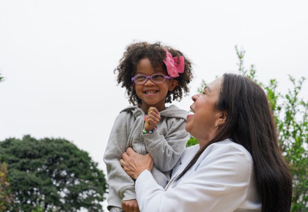 Woman plays with child or granddaughter who is smiling and happy