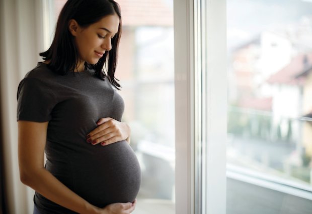 An expecting mother looking down at her belly