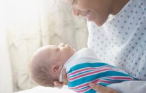 A woman holding her newborn baby in her hospital bed