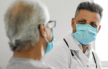 Doctor speaking to patient while masked