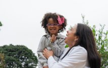 Woman plays with child or granddaughter who is smiling and happy