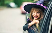A little girl in a car, dressed up like a witch for halloween